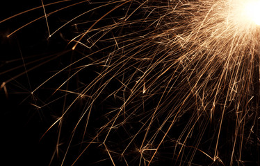 Fire spray from sparklers on black background, macro