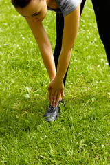 Exercise woman stretching hamstring leg muscles during outdoor running workout.
