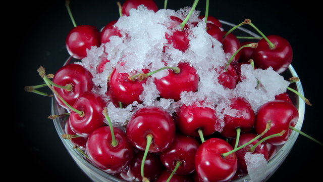 A Group of Ripe Red Cherries on The Plate Beautiful With Snow on The Rotating Table. Close up