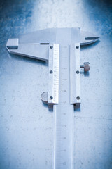 Metal slide caliper on metallic background vertical view constru