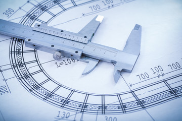 Slide caliper on blueprint close up image construction concept