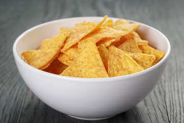 tortilla chips in white bowl on wooden table
