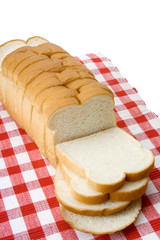 Whole Loaf of Sliced White Bread – Sliced white bread on a red checked tablecloth.
