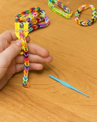 The child's hands doing a bracelet