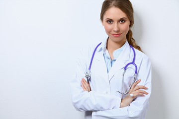 Fototapeta premium Friendly smiling young female doctor, standing near wall