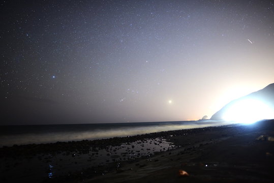  Astrophotography time lapse footage of night seascape with traffic in Malibu Beach, California