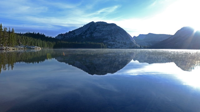  Time lapse footage with tilt up motion of sunrise at reflective lake along Tioga Pass in Yosemite National Park, California