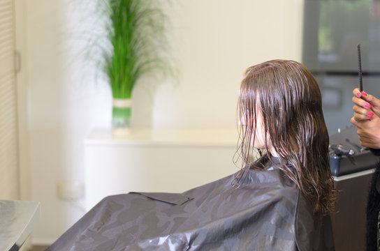 Junge Frau mit Umhang beim Friseur