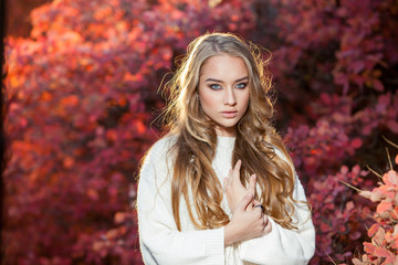 young woman on a background of red and yellow autumn leaves with