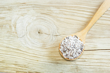 rice on wooden spoon with wooden background. Product of Thailand