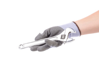 Hand in gloves holding wrench.