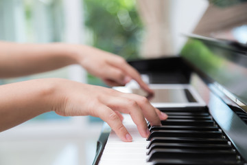 Fototapeta premium Woman hand use tablet and playing piano music