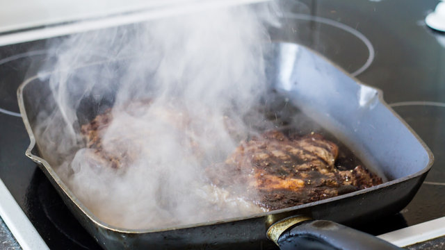 Frying steak on grill plate