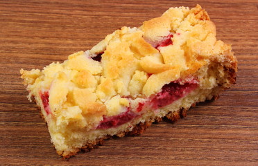 Fresh baked yeast cake with strawberries on wooden table