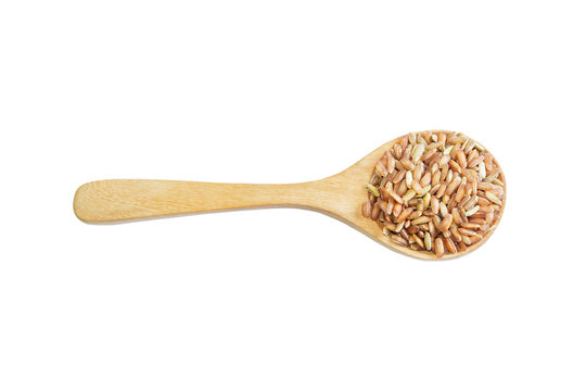 Red rice on wooden spoon with wooden background. Product of Thai