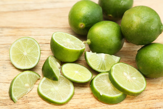 Top view of limes on the wooden board