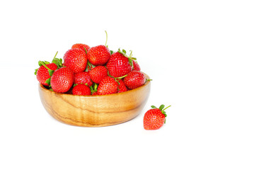 Клубника в деревянной миске на белом фоне.