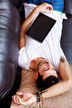 Junger Mann mit Tablett Pc auf dem Sofa 