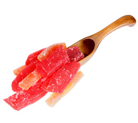 Red and orange dried papaya in the wooden spoon, isolated on whi