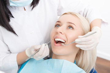 Woman having her teeth examined by dentist 