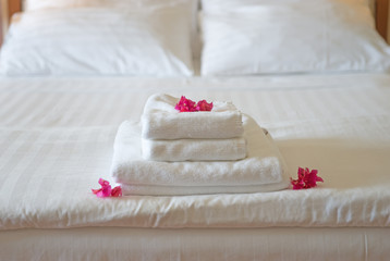 Fototapeta na wymiar Frische Handtücher im Hotel, geschmückt mit Blüten