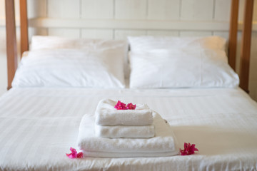 Frische Handtücher im Hotel, geschmückt mit Blüten