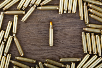 M-16 bullet on wooden table close-up.