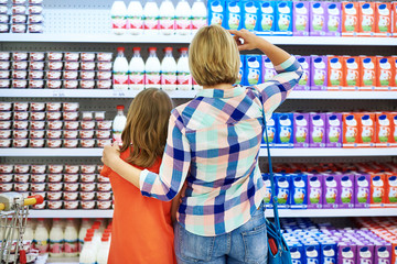 Mother and daughter choosing dairy products