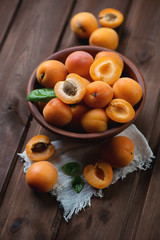 Ceramic bowl with ripe apricots, dark brown wooden background