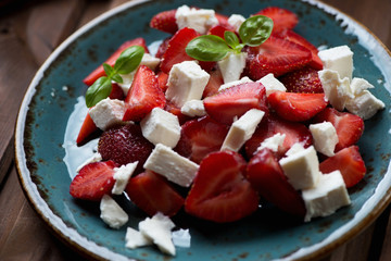 Salad with sliced fresh strawberries and bryndza cheese