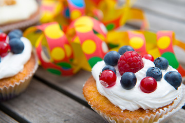 party- muffins with fruits on wooden ground