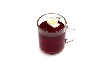 the transparent mug of red drink decorated with a flower,