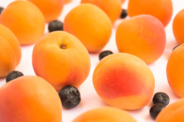 Ripe Fresh Apricots and Blueberries on a White Background