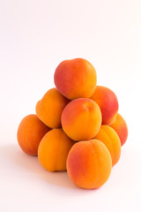 Pyramid of Fresh Ripe Apricots on a White Surface