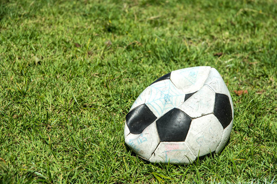 Deflated soccer ball on grass. Soccer concept.