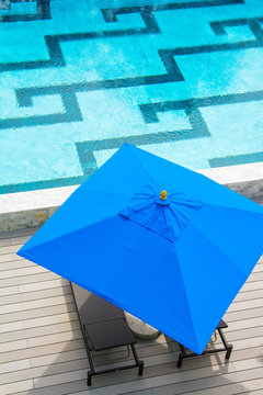 Beach Chair And Blue Umbrella By The Pool