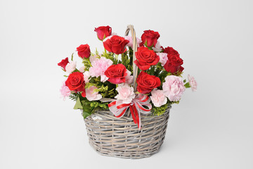 red roses and pink carnations in a basket