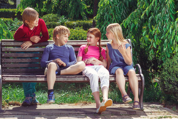 Fototapeta na wymiar Nice smiling children sitting on the bench 