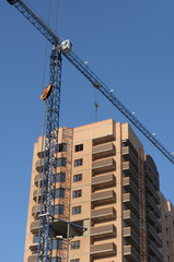 Fototapeta na wymiar Tower crane near the multi-storey house