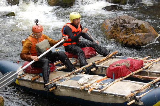 Two men on a makeshift catamaran raft on the northen river.