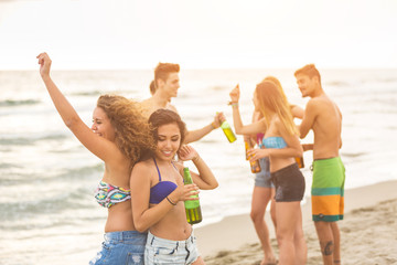 Multiracial group of friends having a party on the beach