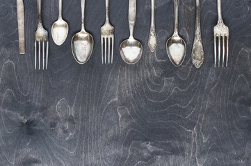 Silver cutlery on the dark wood