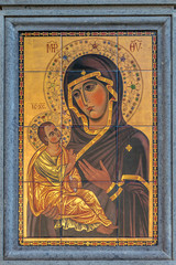 Virgin Mary with child Jesus byzantine style hodegetria icon painted on tiles, on the wall on the street.