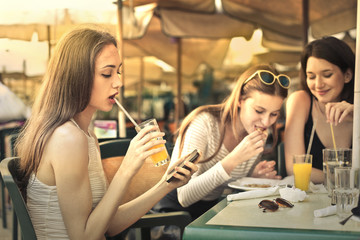 Three girls sitting at a cafe