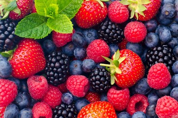 Nahaufnahme unterschiedlicher Beeren: Himbeeren, Blaubeeren, Brombeeren und Erdbeeren mit ein paar...