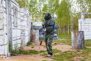 Young woman with paintball marker on training