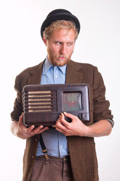 Old-fashioned man holding an old radio