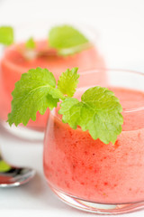 Smoothie drink with mint on table, in high key