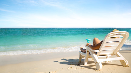 Fototapeta na wymiar Luxury female sunbathing on the beach