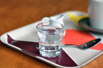 Cup of coffee and glass of water on table in a cafe.